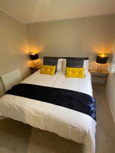 卡纳芬Number 57 Brynteg的卧室配有一张带黄色枕头的大型白色床。
