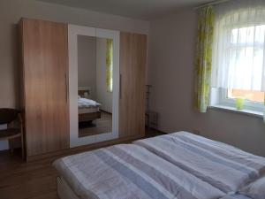 萨克森自由州诺伊斯塔滕Ferienwohnung Karlguth的一间卧室配有一张大床和镜子