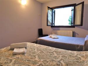 阿斯蒂加拉加ARRASPINE的客房设有两张床和窗户。