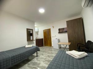 瓦迪穆萨Omar Apartment的带两张床和一张桌子的房间以及一间厨房