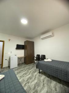 瓦迪穆萨Omar Apartment的一间卧室配有一张床、一张书桌和一台电视。