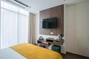 卡塔赫纳Hotel Zi One Luxury的一间酒店客房,配有一张床和一台墙上的电视