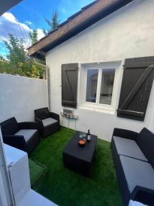 萨利耶德贝阿尔恩Appartement hors du commun avec son jacuzzi的庭院配有黑色家具和绿色草