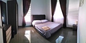 哥打巴鲁Wipah Guest House in Kampung Lundang, Kota Bharu的一间卧室设有一张床和一个窗口