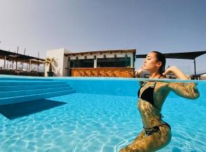 普拉坦斯Atermono Boutique Resort & Spa的坐在游泳池的美人鱼服装中的女人