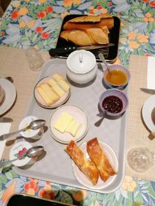 波利尼Chambre et table d'hôtes La Meule的桌上的食品托盘,包括奶酪和面包