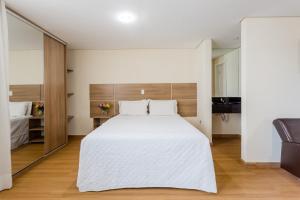 尤西德福拉胜利套房酒店的卧室配有一张白色大床和镜子