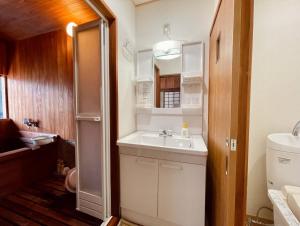 由布市旅館 竹屋 Takeya的一间带水槽和冰箱的小浴室