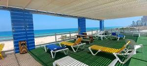 巴特亚姆מלון דירות על הים בת ים 39的阳台配有桌椅,享有海滩美景