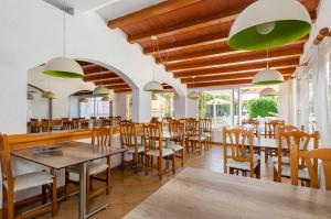 阿尔库迪亚港Mariner Club的用餐室配有木桌和椅子