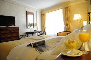 圣达菲InterTower Hotel的酒店客房,配有一张带食品和饮料托盘的床