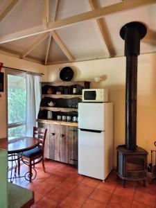 莱克斯恩特伦斯卡里姆纳伍兹小屋旅馆的厨房配有白色冰箱和炉灶。