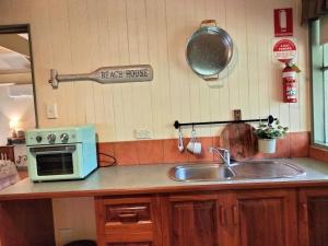 莱克斯恩特伦斯卡里姆纳伍兹小屋旅馆的厨房配有水槽和微波炉