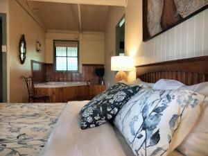 莱克斯恩特伦斯卡里姆纳伍兹小屋旅馆的一间卧室配有一张床,浴室设有水槽
