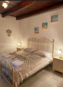 弗卢米尼马焦雷A casa di Nonna IUN Q2951的一间卧室配有一张带两张桌子和两盏灯的床。