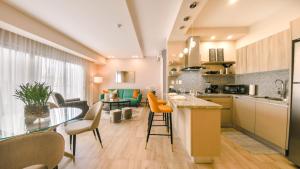 圣多明各Fully Serviced Apartment at Regatta Living II - 6C的厨房以及带桌椅的起居室。