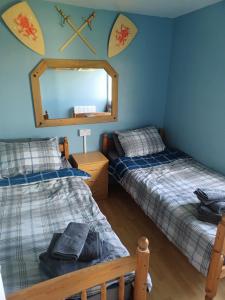 Kidwelly2-bedroom Holiday Home With Great Outdoor Space的配有镜子的客房内的两张床