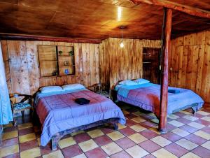 圣拉蒙Batsu EcoLodge & Coffee Farm的木墙客房的两张床