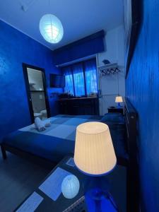 阿韦利诺Light Home的蓝色的卧室配有一张床和一张带台灯的桌子