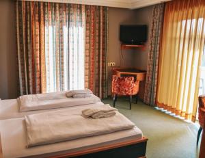 施马伦贝格Parkhotel Schmallenberg的酒店客房设有两张床和电视。