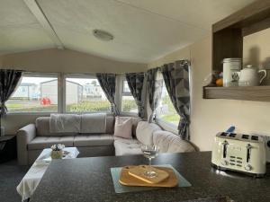 纽顿Trecco Bay Porthcawl Caravan 8 berth PALMS 4的客厅配有沙发和桌子