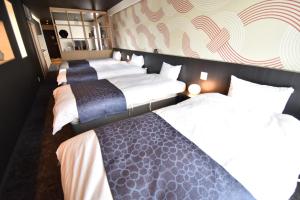 ShimmachidōriK-style gosyonishi的酒店客房设有三张床和一堵墙