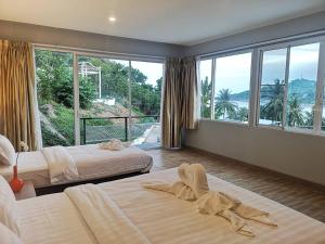 哈林海滩So Good Haad Rin Resort的一间卧室设有两张床和大窗户