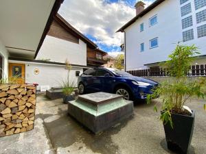 加尔米施-帕滕基兴"Mittendrin" in Garmisch的停在房子前面的蓝色汽车
