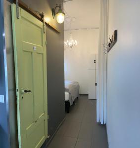 惠拉盖尔济Mörk Guesthouse的走廊上设有绿门和一间卧室
