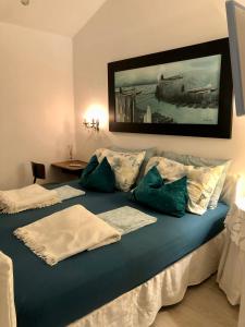 Haus Senter的一张带枕头的大型蓝色床和墙上的绘画