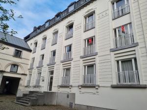 蒙斯Logement dans le cœur historique de Mons的大型白色建筑,设有窗户和阳台