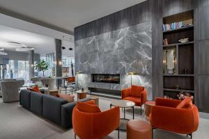 里加拉脱维亚里加丽笙会议水疗酒店的客厅设有壁炉和橙色椅子
