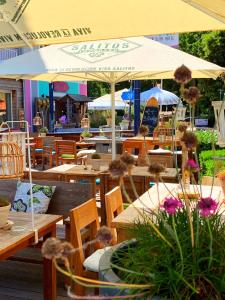 奥斯赛拜-屈隆斯博恩feels Beach Club Hotel的餐厅设有木桌、椅子和遮阳伞