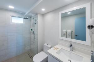 基督教堂市Blue Haven Holiday Apartments的带淋浴和盥洗盆的白色浴室