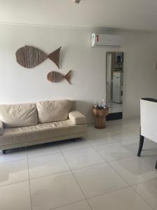 嘎林海斯港Beach Class Muro Alto Condomínio Resort - New Time的客厅配有沙发和墙上的两条鱼