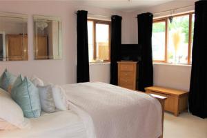 LlanstadwellTide Cleddau impressive detached 4 bedroom home - Llanreath的卧室配有白色的床和镜子