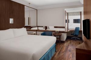 利雅德利雅得民哈尔皇冠假日酒店的配有一张床和一张书桌的酒店客房