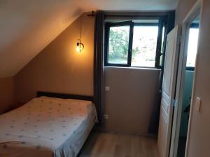 班纳萨克Appartement chaleureux avec Jacuzzi的一间小卧室,配有床和窗户