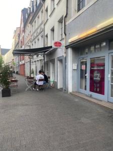 特里尔Schöne und Gemütliche Wohnung in Trier Zentrum的两人坐在大楼外的桌子上