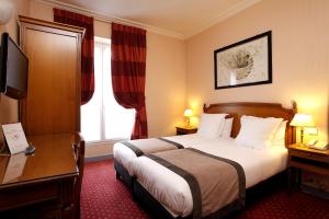 巴黎巴那斯峰达格尔酒店的配有一张床和一张书桌的酒店客房