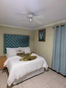 开普敦MO MAJOR的卧室配有一张大白色的床和风扇