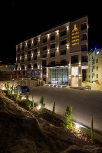 瓦迪穆萨Petra Moon Luxury Hotel的一座建筑,在晚上前有停车位