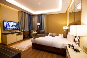 瓦迪穆萨Petra Moon Luxury Hotel的酒店客房设有一张大床和一台电视。