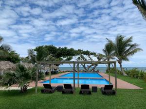 翡翠海岸Mar De Estrellas - Hotel的一个带椅子的游泳池和一个凉亭