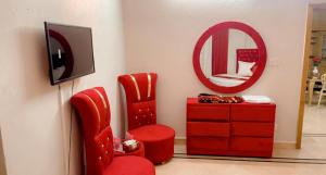 伊斯兰堡Galaxy Lodge的一间设有红色椅子、梳妆台和镜子的房间