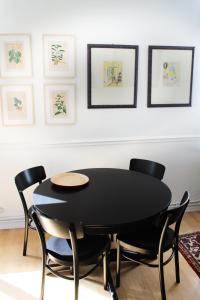 安特卫普Holiday Home Huis Dujardin 1的一张黑色的桌子和椅子,放在画作的房间