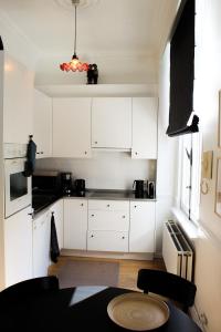 安特卫普Holiday Home Huis Dujardin 1的厨房配有白色橱柜和桌子