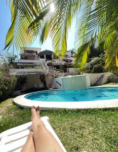 圣克鲁斯华特库Agua Azul la Villa的躺在游泳池旁的吊床上的女人