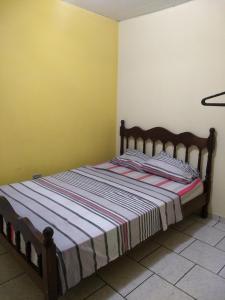 圣卡洛斯Kitnets Plus的卧室配有一张床铺,位于一个黄色墙壁的房间
