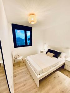 大加那利岛拉斯帕尔马斯Acogedor y cómodo apartamento con piscina的白色的卧室设有床和窗户